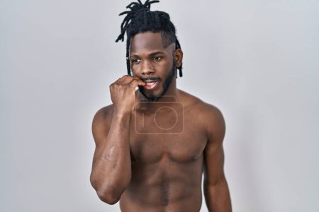 Photo for African man with dreadlocks standing shirtless over isolated background looking stressed and nervous with hands on mouth biting nails. anxiety problem. - Royalty Free Image