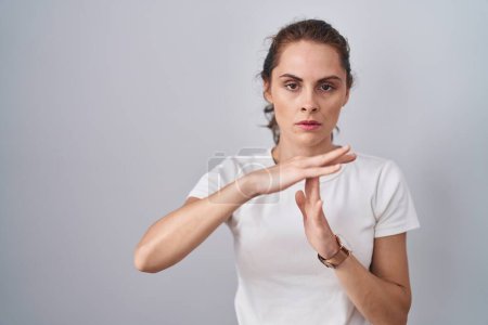 Téléchargez les photos : Belle femme brune debout sur fond isolé faisant un geste avec les mains, frustré et sérieux visage - en image libre de droit