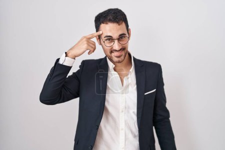 Photo for Handsome business hispanic man standing over white background smiling pointing to head with one finger, great idea or thought, good memory - Royalty Free Image