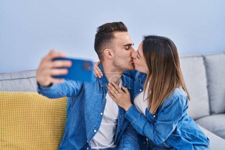 Téléchargez les photos : Homme et femme couple font selfie par smartphone assis sur le canapé à la maison - en image libre de droit