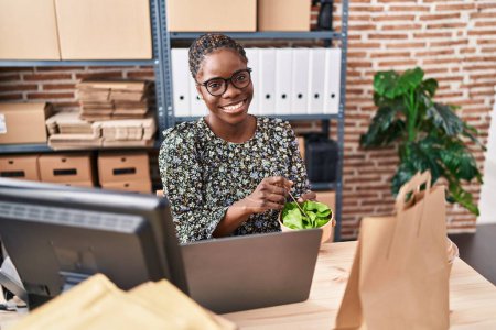 Téléchargez les photos : Femme afro-américaine ecommerce travailleur d'affaires manger de la salade au bureau - en image libre de droit
