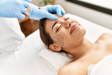 Photo for Young latin woman relaxed having anti aging lips treatment at beauty center - Royalty Free Image