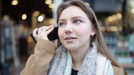 Téléchargez les photos : Young blonde woman smiling confident listening audio message by the smartphone at street - en image libre de droit