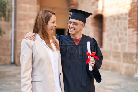 Photo for Man and woman mother and son hugging each other celebrating graduation at university - Royalty Free Image