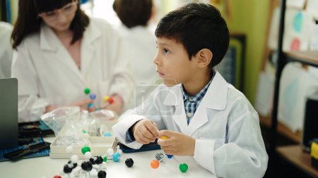 Téléchargez les photos : Adorable garçon et fille étudiants jouant avec des molécules jouet en salle de classe de laboratoire - en image libre de droit