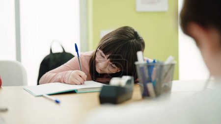 Téléchargez les photos : Adorable hispanique fille étudiant écriture sur ordinateur portable à la salle de classe - en image libre de droit