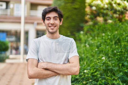 Photo for Young hispanic man standing with arms crossed gesture at park - Royalty Free Image