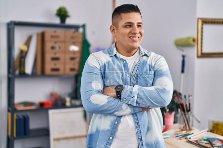 Téléchargez les photos : Jeune homme latino artiste souriant confiant debout avec les bras croisés geste au studio d'art - en image libre de droit