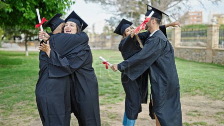 Foto de Grupo de personas estudiantes se graduaron sosteniendo diploma abrazándose en el campus universitario - Imagen libre de derechos