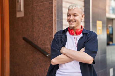 Foto de Young caucasian man smiling confident standing with arms crossed gesture at street - Imagen libre de derechos