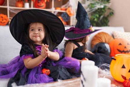 Photo for Adorable twin girls having halloween party clapping hands at home - Royalty Free Image