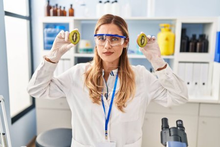 Photo for Young blonde scientist woman working with food at laboratory skeptic and nervous, frowning upset because of problem. negative person. - Royalty Free Image