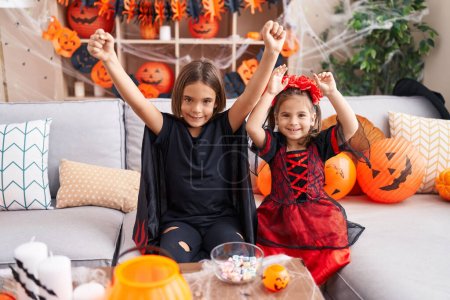 Téléchargez les photos : Adorable garçon et fille ayant fête d'Halloween avec expression gagnante à la maison - en image libre de droit