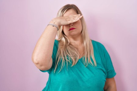Photo for Caucasian plus size woman standing over pink background covering eyes with hand, looking serious and sad. sightless, hiding and rejection concept - Royalty Free Image