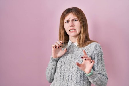 Photo for Beautiful woman standing over pink background disgusted expression, displeased and fearful doing disgust face because aversion reaction. - Royalty Free Image