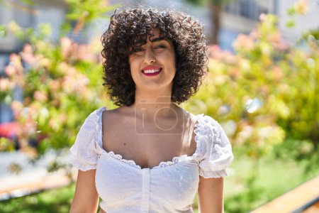 Téléchargez les photos : Jeune femme du Moyen-Orient souriant confiant debout au parc - en image libre de droit