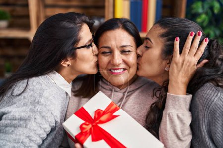 Photo for Three woman surprise with gift sitting on sofa at home - Royalty Free Image