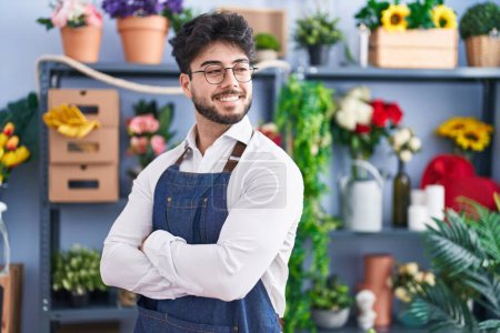 Photo for Young hispanic man florist smiling confident standing with arms crossed gesture at florist shop - Royalty Free Image