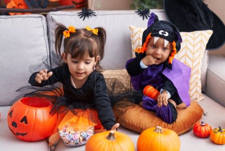 Foto de Adorable chico y chica teniendo halloween fiesta chupando dedo en casa - Imagen libre de derechos