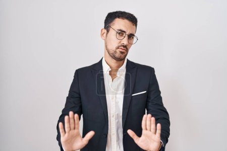 Photo for Handsome business hispanic man standing over white background moving away hands palms showing refusal and denial with afraid and disgusting expression. stop and forbidden. - Royalty Free Image