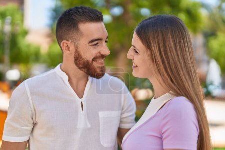 Foto de Hombre y mujer pareja sonriendo confiados abrazándose en el parque - Imagen libre de derechos