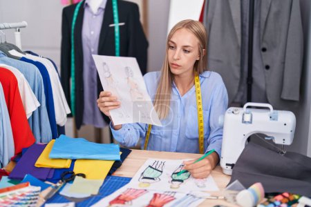 Téléchargez les photos : Jeune femme blonde dessin sur mesure conception de vêtements au magasin de tailleur - en image libre de droit