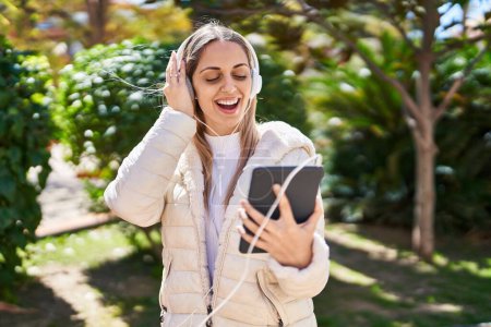 Photo for Young woman smiling confident listening to music at park - Royalty Free Image