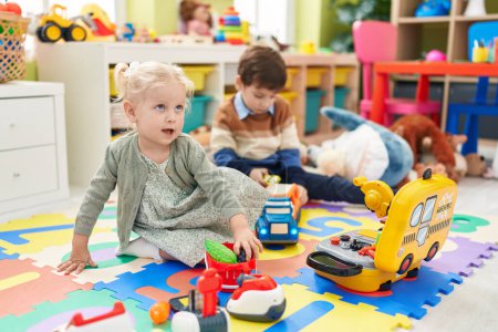 Foto de Adorable niño y niña jugando juego de supermercado y con juguetes de coche en el jardín de infantes - Imagen libre de derechos