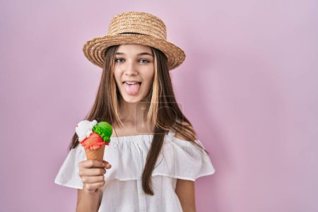 Photo for Teenager girl holding ice cream sticking tongue out happy with funny expression. emotion concept. - Royalty Free Image