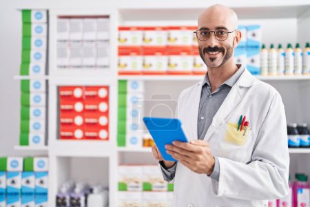Photo for Young hispanic man pharmacist using touchpad at pharmacy - Royalty Free Image