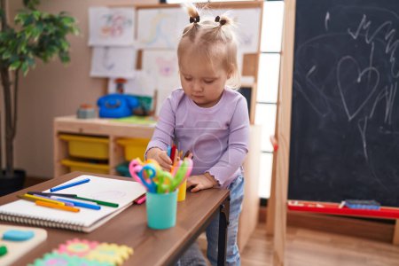 Photo for Adorable blonde girl preschool student holding color pencils at kindergarten - Royalty Free Image