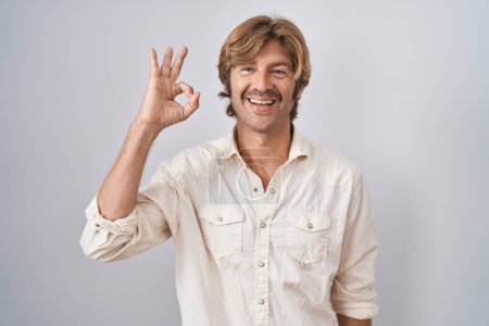 Téléchargez les photos : Homme d'âge moyen debout sur fond isolé souriant positif faire ok signe avec la main et les doigts. expression réussie. - en image libre de droit