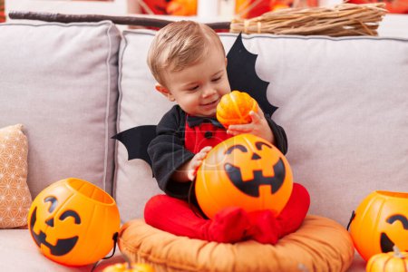 Photo for Adorable caucasian boy wearing bat costume having halloween party at home - Royalty Free Image
