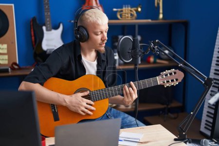 Photo for Young caucasian man musician singing song playing classical guitar at music studio - Royalty Free Image