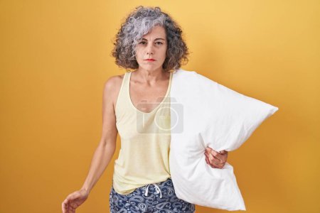 Photo for Middle age woman with grey hair wearing pijama hugging pillow depressed and worry for distress, crying angry and afraid. sad expression. - Royalty Free Image