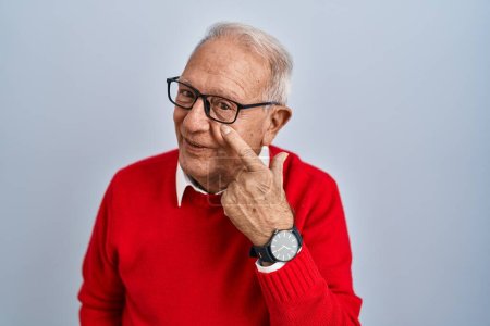 Photo for Senior man with grey hair standing over isolated background pointing to the eye watching you gesture, suspicious expression - Royalty Free Image
