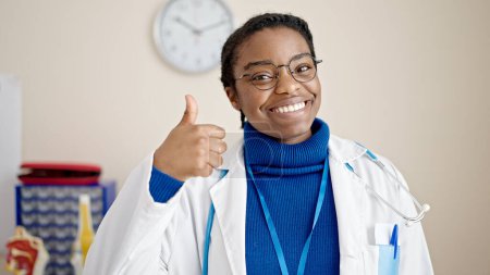 Téléchargez les photos : Femme afro-américaine médecin faire pouce vers le haut à la clinique - en image libre de droit