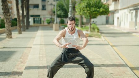 Photo for Young hispanic man karate fighter training at park - Royalty Free Image