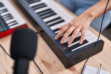 Téléchargez les photos : Jeune musicienne hispanique jouant du clavier piano au studio de musique - en image libre de droit