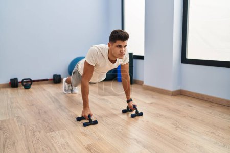 Photo for Young hispanic man training push up at sport center - Royalty Free Image