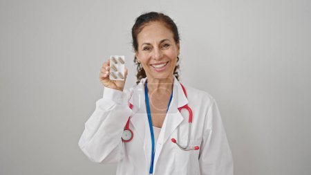 Téléchargez les photos : Moyen Age hispanique femme médecin tenant des pilules sur fond blanc isolé - en image libre de droit