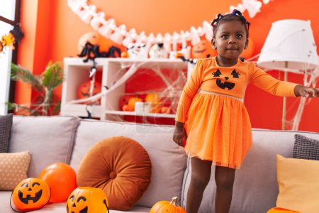 Photo for African american girl having halloween party wearing pumpkin costume at home - Royalty Free Image