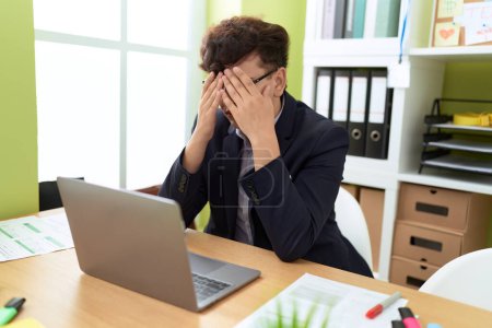 Téléchargez les photos : Non binary man business worker stressed using laptop at office - en image libre de droit