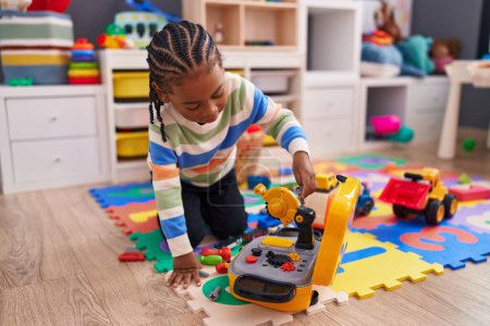Photo for African american boy playing with toy sitting on floor at kindergarten - Royalty Free Image