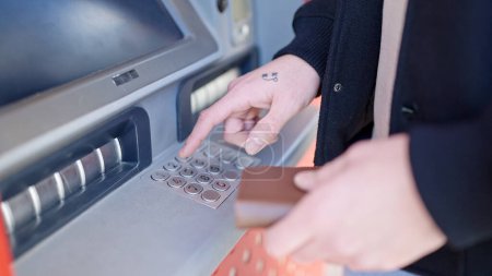 Photo for Young arab man pressing password on bank machine at street - Royalty Free Image