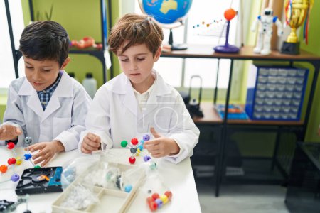 Téléchargez les photos : Adorables garçons étudiants jouant avec des molécules jouet en salle de classe de laboratoire - en image libre de droit