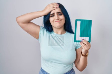 Photo for Young modern girl with blue hair holding l sign for new driver stressed and frustrated with hand on head, surprised and angry face - Royalty Free Image