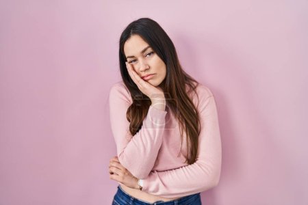 Téléchargez les photos : Young brunette woman standing over pink background thinking looking tired and bored with depression problems with crossed arms. - en image libre de droit
