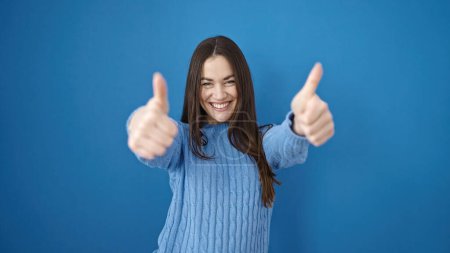Photo for Young caucasian woman smiling with thumbs up over isolated blue background - Royalty Free Image