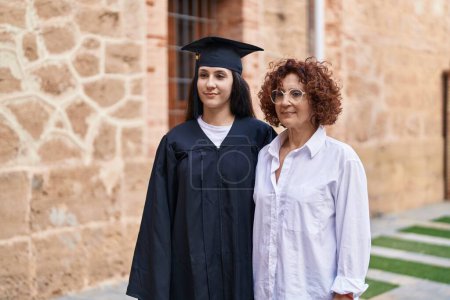 Photo for Two women mother and daughter celebrating graduation at campus university - Royalty Free Image